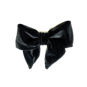 A black velvet hair bow barrette on a white background.