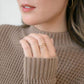 close up of hand wearing double wrap ring
