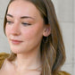 blonde model wearing simple gold hoop earrings