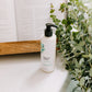 Thistle Farms Rest hand lotion with eucalyptus and mint next to dried eucalyptus.
