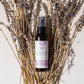 Thistle Farms moisturizing hair conditioner bottle surrounded by lavender flowers on a light background