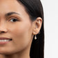 Woman wearing Journey of Hope Huggie Earrings and Leeda Freshwater Pearl Earrings in Sterling Silver. Classic and minimalist design.