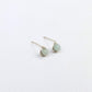 Pair of silver stud earrings with green gemstones on a white background