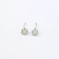 Pair of silver stud earrings with light green gemstone beads on a white background