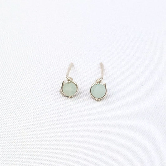 Pair of silver stud earrings with light green gemstone beads on a white background