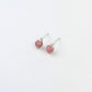 a pair of silver stud earrings with pink beads on a white background