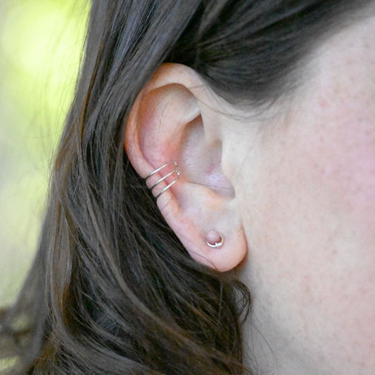 a pair of silver stud earrings with pink beads on a white background