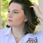 model wearing sterling silver stud earrings featuring a pink rhodonite bead and a coordinating necklace