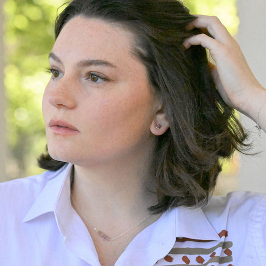 a pair of silver stud earrings with pink beads on a white background