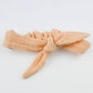 Peach-colored headband with a bow on a white background