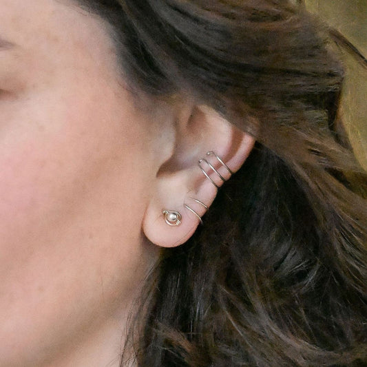 pair of gold earrings with silver bead at the center