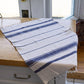 Striped towel on a wooden surface with a window in the background