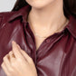 A woman wearing a maroon leather shirt and a 14k gold filled chain necklace with a brass chevron pendant.