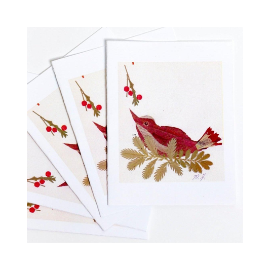 Set of Christmas-themed cards with red birds and green leaves made from dried and handcut botanicals on a white background