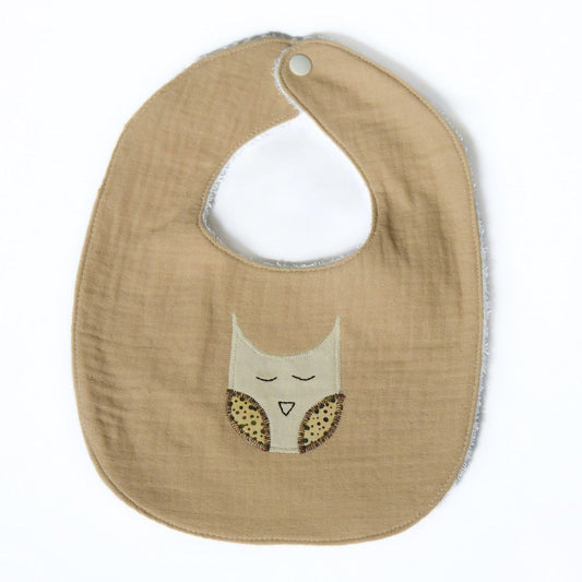 tan baby bib with owl design on a white background
