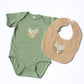Green baby onesie with owl design and tan bib with owl design on a white background