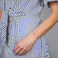 woman in a blue and white striped dress wearing a silver chain bracelet with four pink rhodonite beads in the center