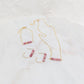 a collection of gold jewelry featuring a necklace, bracelet and earrings each with pink rhodonite beads