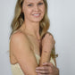 blonde woman wearing gold earrings, necklace and bracelet adorned with pink rhodonite beads