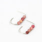 a pair of sterling sivler j-shaped earrings each with four pink stone beads