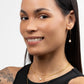 A young woman in a black tank top wearing Rana Pearl Threader Earrings, Leeda Pearl Necklace and Elizabeth Paperclip Necklaces in 14k Gold Filled.