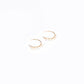 Delicate 14k gold filled C hoop earrings with four freshwater rice pearls on a white background
