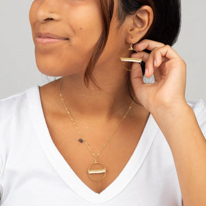 Young woman wearing white v-neck tee and Samira Seeds of Hope Earrings and Necklace in 14k Gold Filled.