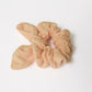 a peach scrunchie made of double cotton guaze on a white background