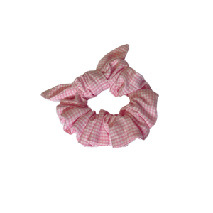 Pink gingham cotton scrunchie on a white background
