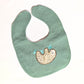 Green baby bib with a sloth design on a white background