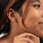 Young woman wearing Zun Zuun Threader Earrings in sterling silver, a geometric, zig-zag design.