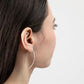 A side profile of a young woman wearing Qasioun Minimalist Threader Earrings in sterling silver.