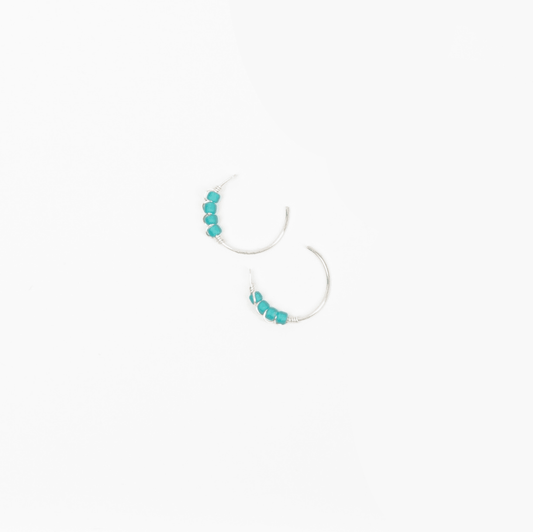 A close-up image of a woman's ear wearing Moab Western Beaded Threader Earrings in sterling silver. Hoop earring with turquoise beads.