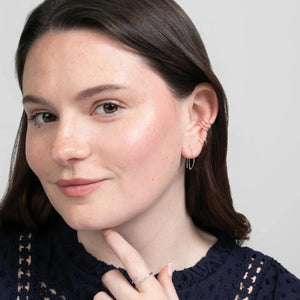 Close-up semi-sideview of woman wearing sterling silver Half Moon Threader earrings, Journey of Hope Huggie Earrings and Ear Cuff.