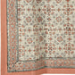 A close-up of a patterned kitchen towel corner showing an ornate floral and scroll motif in muted terracotta, gray, and black on an off-white ground, with a solid terracotta border.