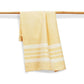 Yellow towel with white stripes hanging on a wooden rack against a white background