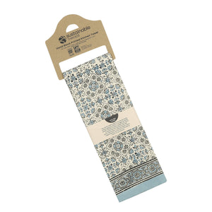 Floral patterned kitchen towel with cardboard holder on a white background