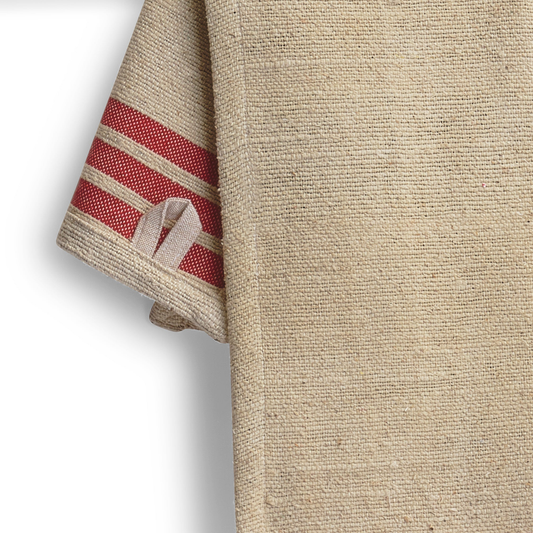 Beige towel with red stripes in packaging on a white background