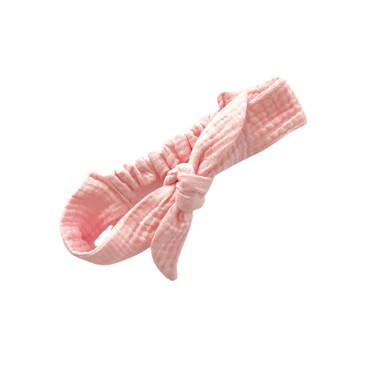 A handmade, adjustable pink double cotton gauze tie headband on white background