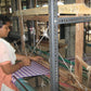 Woman operating a traditional loom in a textile workshop
