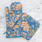 Floral oven mitt and pot holder set on a marble surface