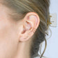 close-up of a blonde woman wearing gold zigzag ear climber earrings and a gold ear cuff