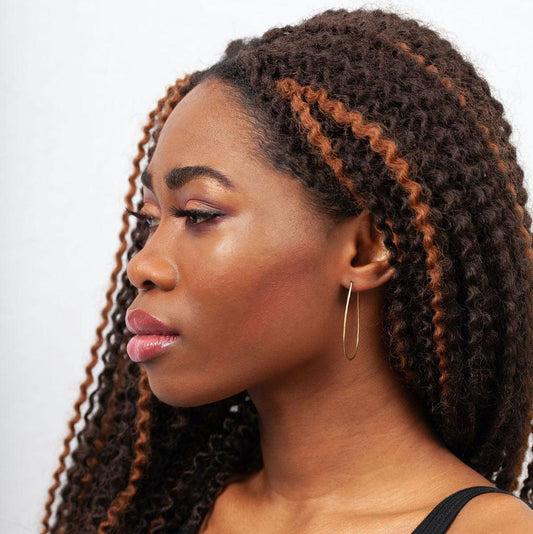 Sideview of woman wearing Azmera Hammered Hoop Earrings in 14k Gold Filled 