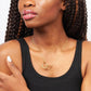 Zomi Circles of Unity Necklace in 14k Gold Filled modeled by young woman in black tank top. 