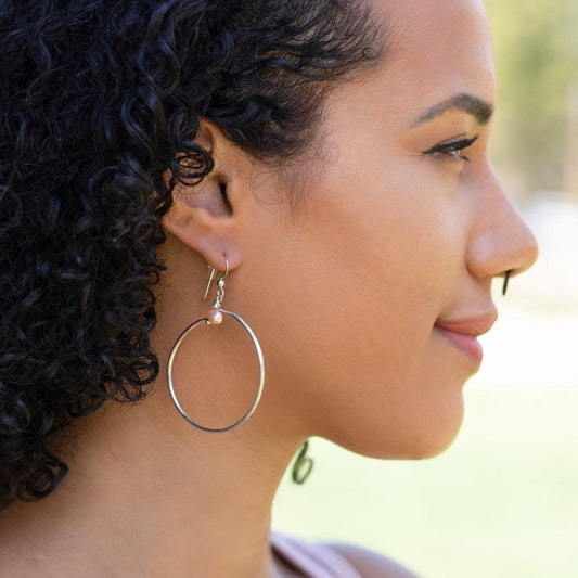 These refugee-made earrings feature a delicate hand-hammered sterling silver hoop topped with a rose freshwater pearl and hang from 14k gold-filled ear wires. Effortless fashion! Forai refugee made gifts.