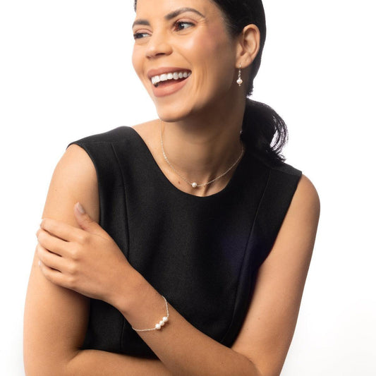 Smiling woman in black wearing the Leeda Freshwater Pearl Bracelet, Earrings and Necklace in Sterling Silver