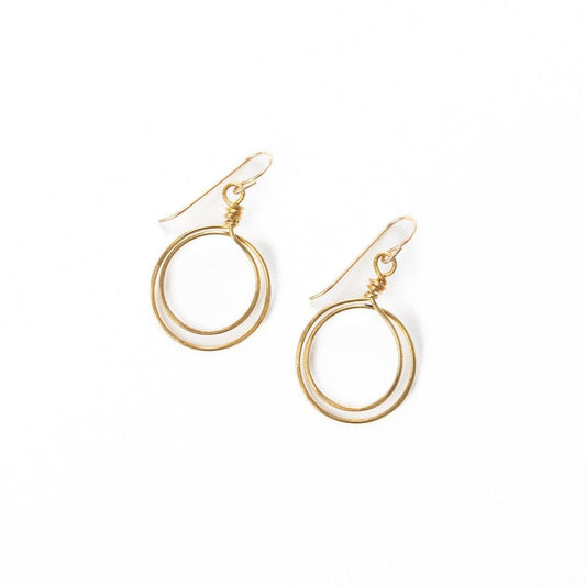 Sideview of young woman wearing Zomi Circles of Unity Earrings in 14k Gold Filled.  Earrings feature a double circle drop of hand-hammered brass.