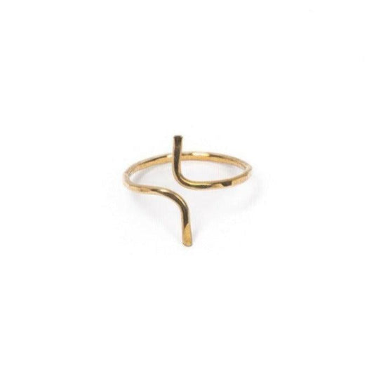 Hand of woman wearing Shanta Hand-hammered Ring in Brass on left hand with other rings.