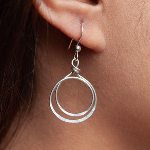 Zomi Circles of Unity Earrings in Sterling Silver on woman's ear.