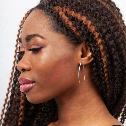 Sideview of woman wearing Azmera Hammered Hoop Earrings in Sterling Silver 
